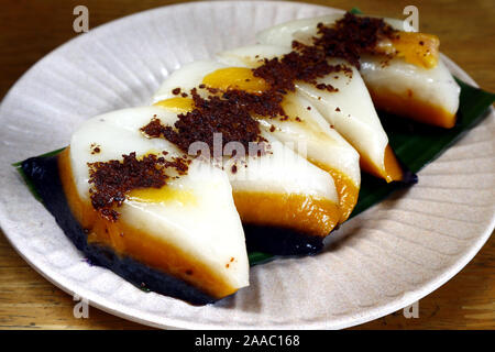 Foto der Schichten der Philippinischen Dessert oder einen Snack essen genannt Sapin sapin oder geschichtete Klebreis mit Lebensmittelfarbe und Kokosmilch Stockfoto