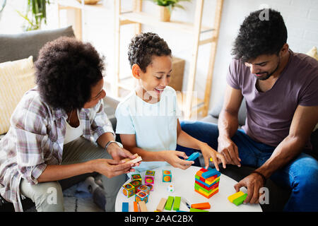 Zeit mit der Familie. Junge schwarze Eltern mit zwei Kindern zusammen zu Hause spielen Stockfoto