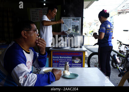 ANTIPOLO CITY, Philippinen - 20 November, 2019: Kunden kaufen und essen an einem Lugawan oder ein Lokal, die spezialisiert auf reisbrei oder Lugaw. Stockfoto