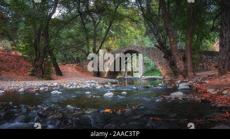 Venezianische Brücke in Zypern in das Troodos-gebirge. Schönen Herbst Landschaft mit Fluss, Bäume und der Alten Brücke. Mittelalterliche Architektur Stockfoto