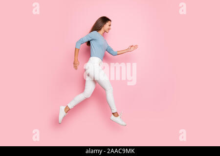 Volle Länge Körper Größe Foto der netten hübschen konzentriert Mädchen läuft in leeren Raum in blauer Pullover für Vertrieb isoliert pastellfarbenen Hintergrund Stockfoto