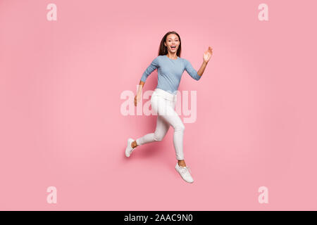 Volle Länge Körper Größe gedreht Foto von positiven trendige Casual Frau in Richtung traum Laufen in Schuhen Aufregung zum Ausdruck auf dem Gesicht rosa isoliert Stockfoto