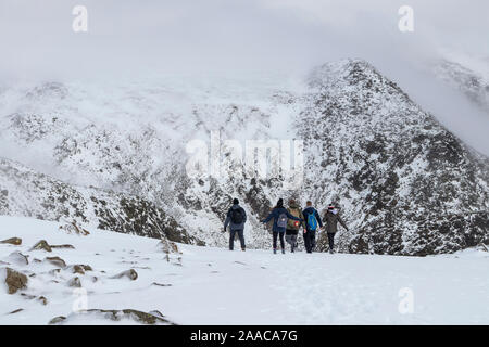 Wanderer auf dem Weg zu einem Nebel eingehüllt Hecht de Bield, vom Gipfel des Scafell Pike, Lake District, Cumbria, Großbritannien Stockfoto