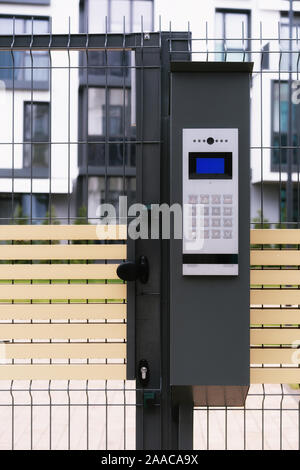 Sicherheit in modernen Wohngebäuden. umzäunter Garten, geschlossene Tor mit elektronischem Schloss. Stockfoto