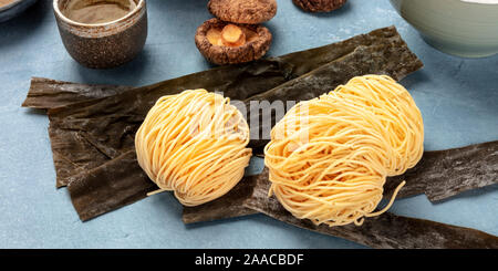 Udon Nudeln, eine panoramische Nahaufnahme mit getrockneten Meer Gemüse Kelp und Shiitake-pilze, Ramen Zutaten Stockfoto