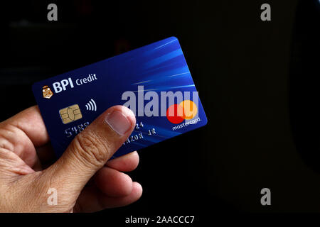 ANTIPOLO CITY, Philippinen - 20 November, 2019: Hand mit einer Kreditkarte Mastercard mit EMV-Chip von BPI- oder Bank der philippinischen Inseln. Stockfoto