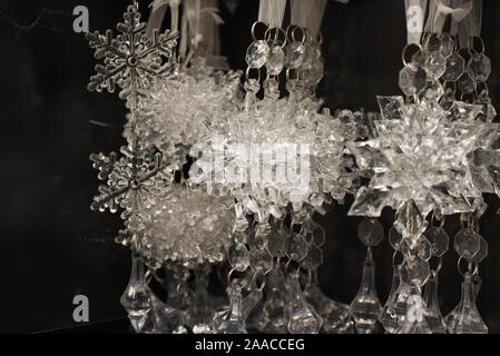 Transparente Weihnachtsbaum Spielzeug Schneeflocken hängen auf einem Regal im Store. Verkauf von schönen Christbaumschmuck. Stockfoto