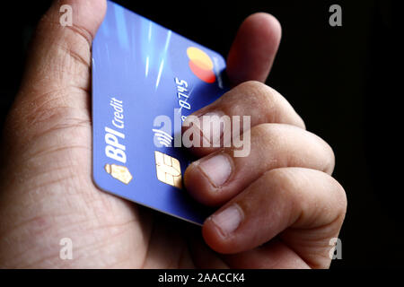 ANTIPOLO CITY, Philippinen - 20 November, 2019: Hand mit einer Kreditkarte Mastercard mit EMV-Chip von BPI- oder Bank der philippinischen Inseln. Stockfoto