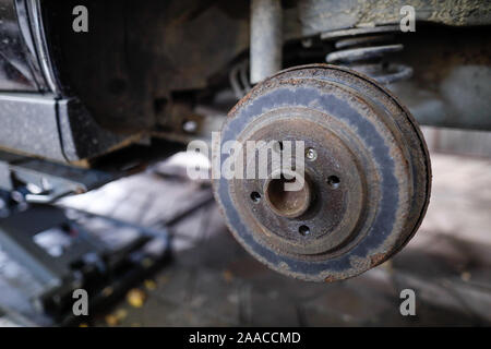 Flache Tiefenschärfe (selektive Fokus) Bild mit einer rostigen Radnabe hinten von einem alten Auto. Stockfoto