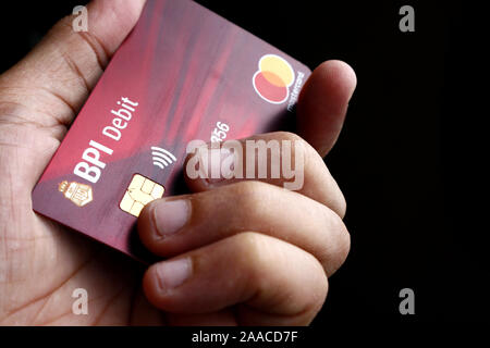 ANTIPOLO CITY, Philippinen - 20 November, 2019: Hand mit einem Soll- oder ATM-Mastercard mit EMV-Chip von BPI- oder Bank der philippinischen Inseln. Stockfoto