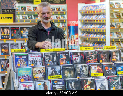 Parchim, Deutschland. 13 Nov, 2019. Video und Film Experte Maik Micheel Art Filme in einem der Regale der Shop von Video Aktuell. Einer der letzten Video Stores in Mecklenburg-Vorpommern Vorpommern seine Türen schließt nach 29 Jahren vor Weihnachten. 1991 eröffnet, die Vermietung Service für Filme, Musik oder Computerspiele angeboten 3000 VHS-Kassetten und 4.000 DVD oder Blue Ray-Titel auf seiner Hochzeit. Von 9000 Deutschlands Videotheken, es gibt weniger als 400 Heute, nach der Vereinigung für Video und Media Einzelhändler. Credit: Jens Büttner/dpa-Zentralbild/ZB/dpa/Alamy leben Nachrichten Stockfoto