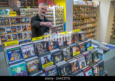 Parchim, Deutschland. 13 Nov, 2019. Video und Film Experte Maik Micheel Art Filme in einem der Regale der Shop von Video Aktuell. Einer der letzten Video Stores in Mecklenburg-Vorpommern Vorpommern seine Türen schließt nach 29 Jahren vor Weihnachten. 1991 eröffnet, die Vermietung Service für Filme, Musik oder Computerspiele angeboten 3000 VHS-Kassetten und 4.000 DVD oder Blue Ray-Titel auf seiner Hochzeit. Von 9000 Deutschlands Videotheken, es gibt weniger als 400 Heute, nach der Vereinigung für Video und Media Einzelhändler. Credit: Jens Büttner/dpa-Zentralbild/ZB/dpa/Alamy leben Nachrichten Stockfoto