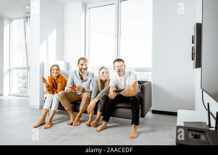 Gruppe von jungen Freunden Spaß beim Spielen von Videospielen auf der Couch zu Hause. Konzept von Freizeit und video Spiele zu Hause Stockfoto