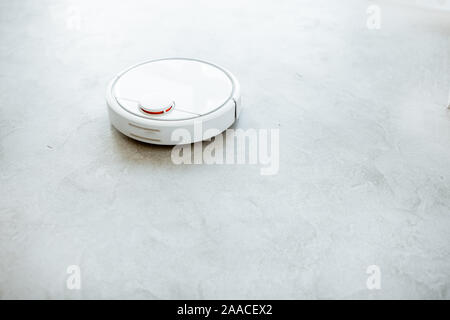 Automatische Staubsauger arbeiten auf dem Boden. Haushalt Roboter Konzept Stockfoto