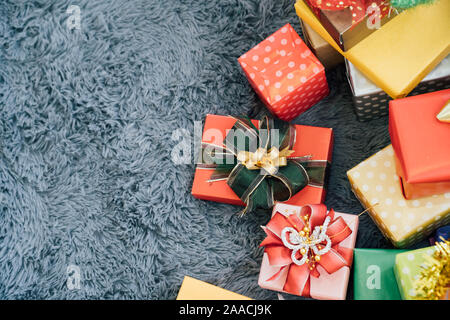 Horizontal oben Blick auf bunte Geschenkboxen mit Bändern über rustikale Hintergrund - mit Kopie Raum Stockfoto