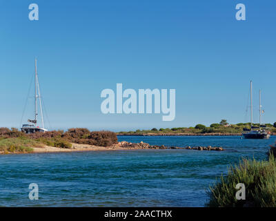 Yachten vor Anker zwischen den Inseln Ilha da Culatra aus der portugiesischen Küste der Algarve auf einem sonnigen, heissen Juli Nachmittag. Stockfoto