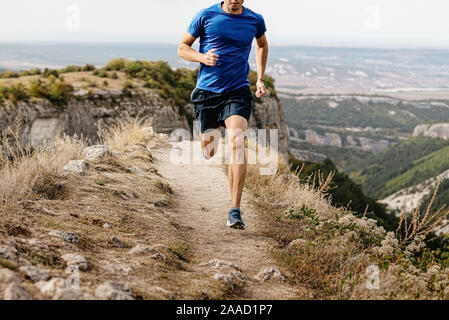 Männliche Läufer mit Mountain Trail am Rand der Klippe Stockfoto