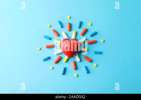 Flach mit Pillen und roten Herzen auf blauem Hintergrund, die Ansicht von oben und Platz für Text Stockfoto