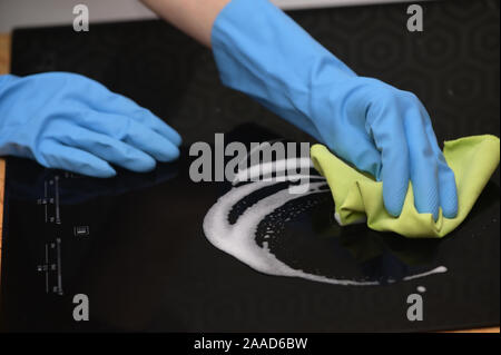 Frau Hände Reinigen einer modernen schwarzen Induktionsherd Stockfoto