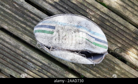 Weißes Leder zerrissen rugby ball auf Holzbrett Hintergrund Stockfoto
