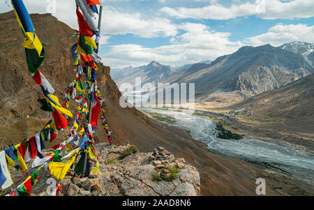 Kaza, Himachal Pradesh, Indien. Die spiti Spiti Fluss schlängelt sich durch das Tal, das von den hohen Gipfeln des Himalaya und Buddhistische Gebetsfahnen flankiert. Stockfoto