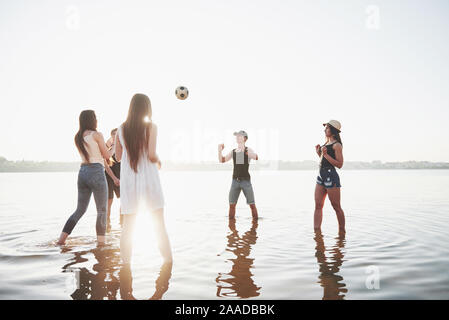 Junge lächelnde Freunden Beachvolleyball spielen auf den See am Nachmittag. Stockfoto