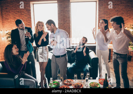 Erstaunliche Stimme. Foto von besten Freunden feiern Neujahr party Karaoke singen Lieder halten Mikrofon klatschen Verschleiß formalwear sitzen Sofa Stockfoto