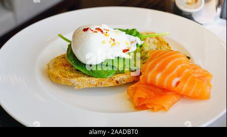 Avocado Toast mit pochiertem Ei und geräuchertem Lachs Stockfoto