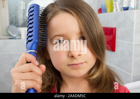 Achtjährige kämmt sich das Haar (pr) Stockfoto