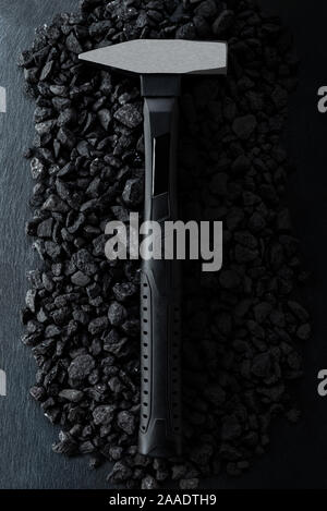 Professionelle verstärkt Schwarz matt Schlosser Hammer auf einem steinigen Hintergrund platziert. Die Aussicht von oben. Stockfoto