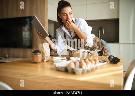Junge Frau in der Küche vorbereiten und proben Zutaten Stockfoto