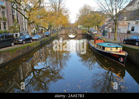 AMSTERDAM, NIEDERLANDE, November 19, 2019: Reflexionen von bunten historischen Gebäuden und einem Hausboot Reguliersgracht, mit Blick auf den Kanal Stockfoto