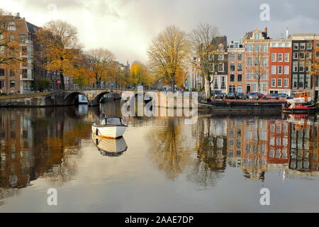 AMSTERDAM, NIEDERLANDE, 19. NOVEMBER 2019: Reflexionen von Gebäuden unter Denkmalschutz und Hausboote, an der Kreuzung zwischen der Amstel und Prinsengracht Stockfoto