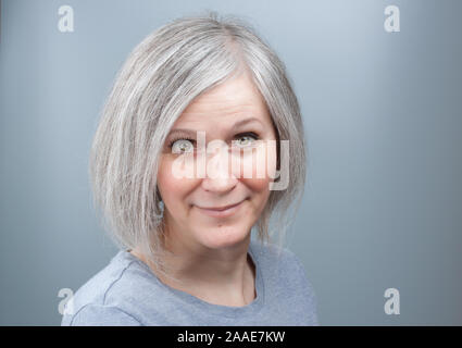 Portrait einer liebenswerten Frau mit grauen Haaren in ihren frühen 50er Jahren Stockfoto