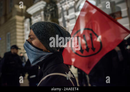 Eine maskierte antifaschistischen Schüler neben der Antifa Flagge während des Protestes gesehen. Anti-Fascists Studenten und Aktivisten an der Warschauer Universität unter dem Motto "Hier lernen wir, uns nicht Hagel (ein Nazi Geste gruss Hitler), blockieren die Tore zum Campus aus einer Gruppe von Nationalisten, die wollte eine so genannte Protest von Linken unterstützt Schüler mit Migrationshintergrund und die indoktrination der polnischen Studenten durch LGBTQ Lobby zu halten. Stockfoto