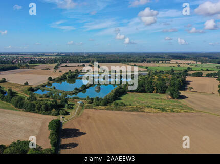 Luftaufnahme von Fischteichen mit blauen Wasser zwischen Feldern und landwirtschaftlichen Flächen Stockfoto