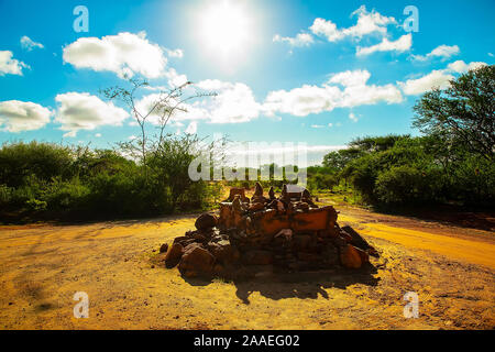 Eine kleine Herde von wilden Grüne Meerkatzen sitzt auf große Steine im Tsavo Nationalpark in Kenia bei Sonnenuntergang. Paviane Herde hautnah. Augen zu Augen. Stockfoto