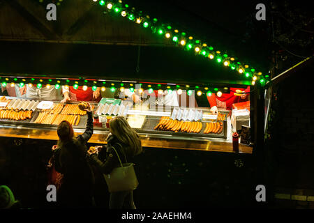 Freiburg im Breisgau, Deutschland. Nov, 2019 21. Eine Frau nimmt Ihre bratwurst Roll auf dem Weihnachtsmarkt in Freiburg. Der Freiburger Weihnachtsmarkt heute Abend offiziell eröffnet werden. Credit: Philipp von Ditfurth/dpa/Alamy leben Nachrichten Stockfoto