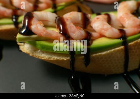 Bruschetta mit Garnelen, Avocado und Kalk auf einen dunklen Platte Stockfoto