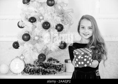 Träume werden wahr. Am besten für unsere Kinder. Junge Mädchen in der Nähe von Weihnachten Baum halten Geschenkbox. Kind feiern Weihnachten zu Hause. Lieblings Tag des Jahres. Weihnachten Geschenke zu öffnen. Öffnung Weihnachtsgeschenke. Stockfoto