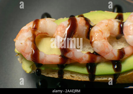 Bruschetta mit Garnelen, Avocado und Kalk auf einen dunklen Platte Stockfoto