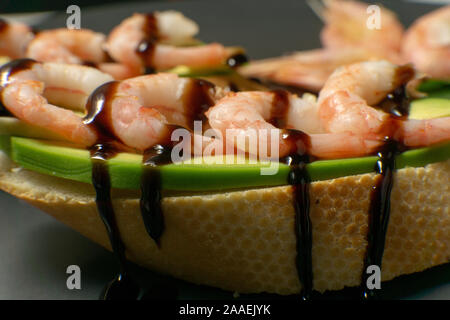 Bruschetta mit Garnelen, Avocado und Kalk auf einen dunklen Platte Stockfoto