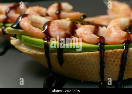 Bruschetta mit Garnelen, Avocado und Kalk auf einen dunklen Platte Stockfoto