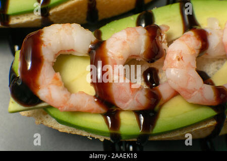 Bruschetta mit Garnelen, Avocado und Kalk auf einen dunklen Platte Stockfoto