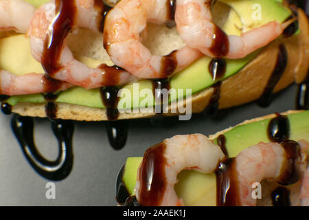 Bruschetta mit Garnelen, Avocado und Kalk auf einen dunklen Platte Stockfoto