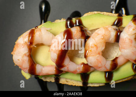 Bruschetta mit Garnelen, Avocado und Kalk auf einen dunklen Platte Stockfoto