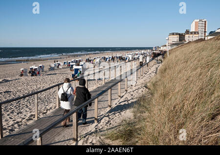 Urlauber an der Strandpromenade und am Strand von Westerland auf Sylt geniessen die Abendsonne mit Blick auf das Meer Stockfoto