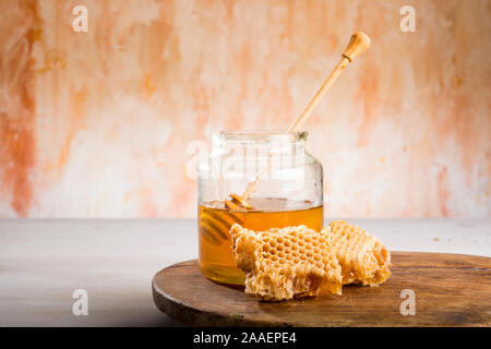 Honig und den Pendelarm in Glas Glas auf einem Holzboden Stockfoto
