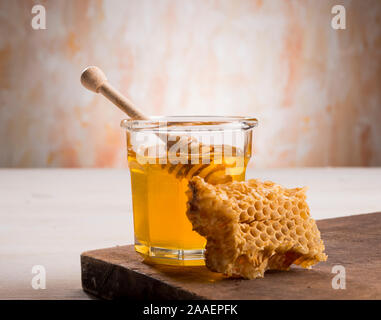 Honig und den Pendelarm in Glas Glas auf einem Holzboden Stockfoto