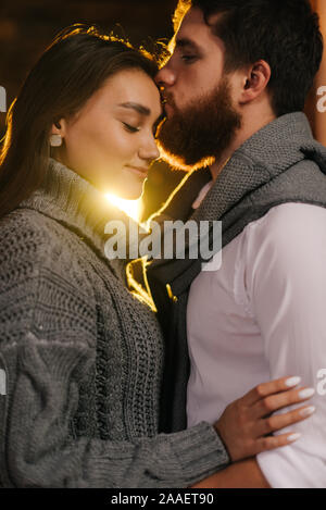 Junger Mann küsst seine Freundin auf der Stirn. Stockfoto